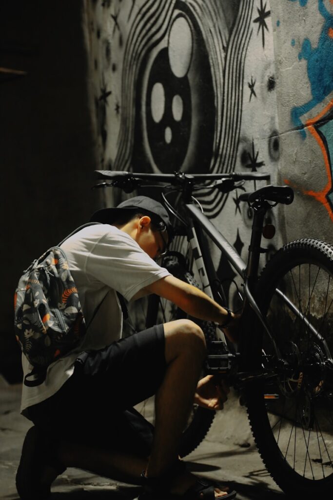 a man kneeling down next to a bike